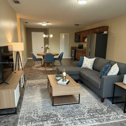 a living room with furniture rug and lamp