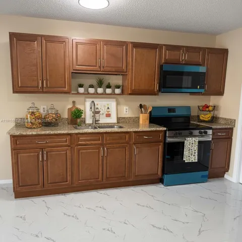 a kitchen with stainless steel appliances granite countertop a sink stove and microwave