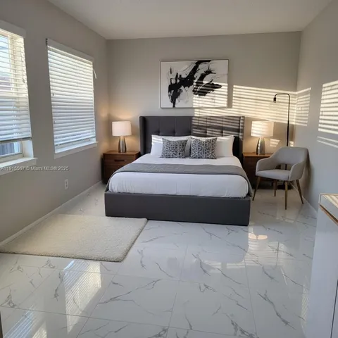 a bedroom with a bed a lamp and window