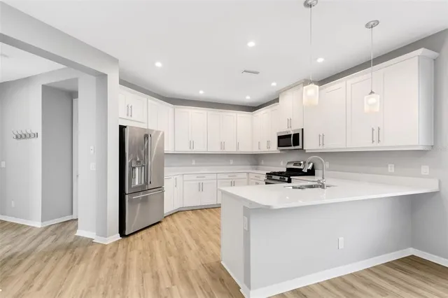 a kitchen with stainless steel appliances granite countertop a refrigerator and a sink