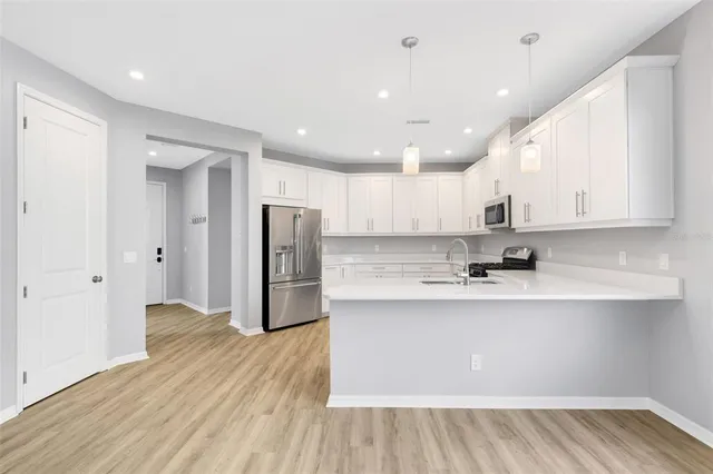 a kitchen with stainless steel appliances granite countertop a sink and white cabinets