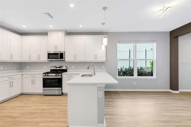 a kitchen with white cabinets and stainless steel appliances
