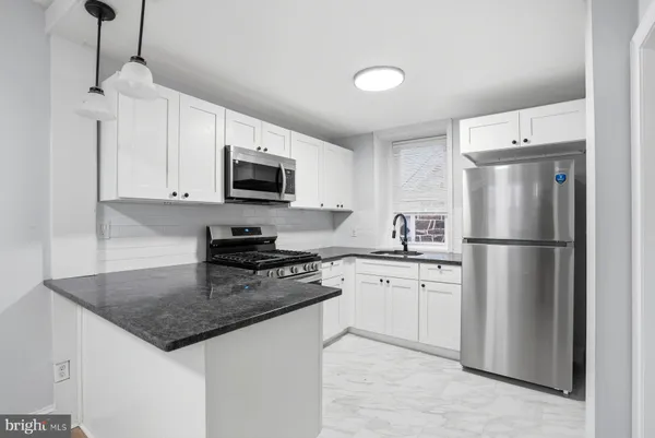 a kitchen with stainless steel appliances granite countertop a stove a refrigerator a microwave a sink and dishwasher