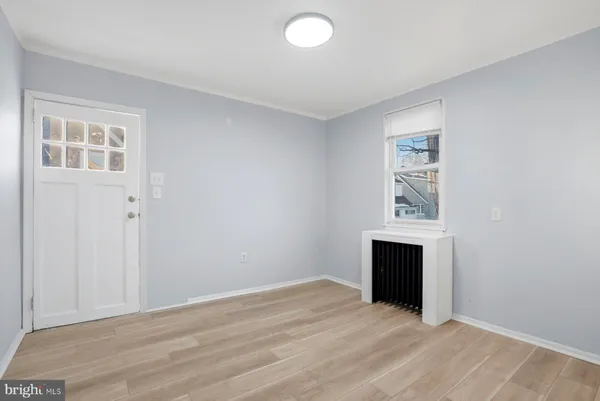 an empty room with windows and fireplace