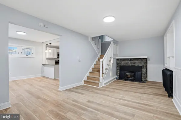 a view of a livingroom with wooden floor fireplace and staircase