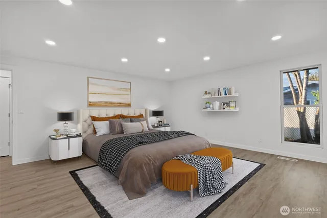 a spacious bedroom with a bed and wooden floor