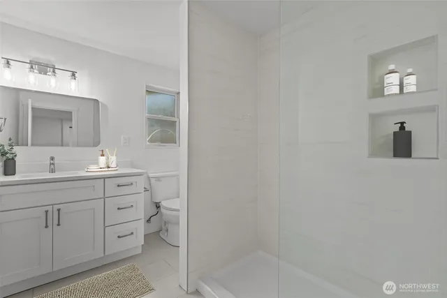 a bathroom with a double vanity sink a toilet and mirror