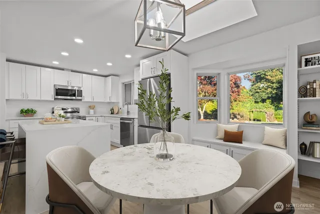 a kitchen with stainless steel appliances granite countertop a kitchen island hardwood floor sink stove and dining table