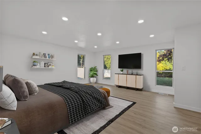 a spacious bedroom with a bed and a flat screen tv