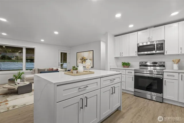 a kitchen with stainless steel appliances granite countertop a sink a stove and cabinets