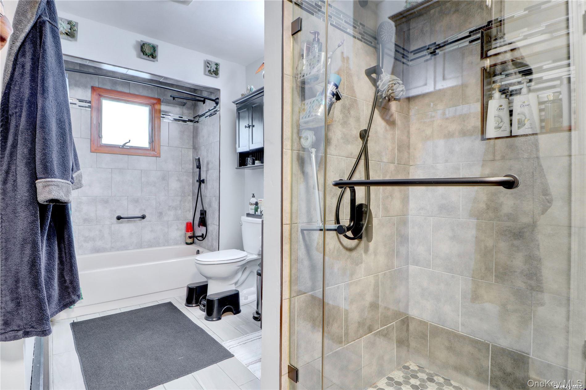 338 Cold Spring Road Syosset, NY 11791 - Photo 10 of 22 Full bath with tile patterned floors and tiled shower / bath