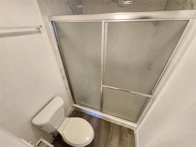 a bathroom with a toilet and a shower