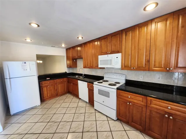 a kitchen with stainless steel appliances granite countertop a stove a sink dishwasher and a refrigerator with cabinets