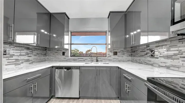 a kitchen with stainless steel appliances granite countertop a sink stove and cabinets