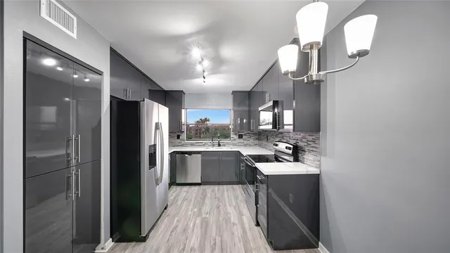 a view of a hallway with wooden floor and chandelier