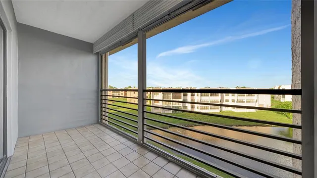a view of an empty room with window and chandelier