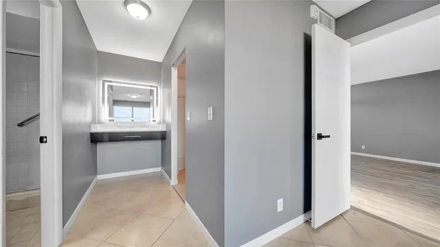a bathroom with a sink mirror and shower