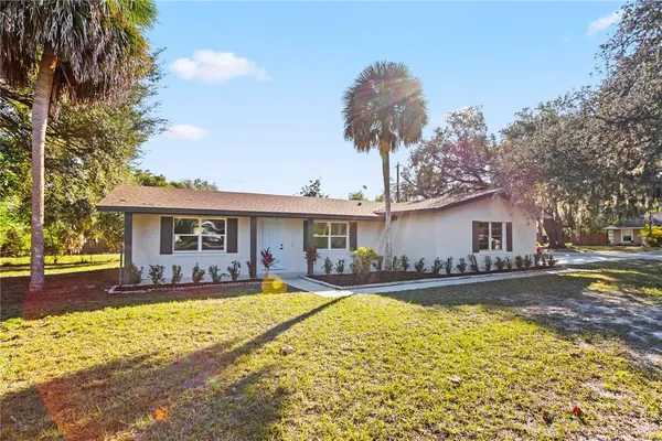 a front view of a house with a yard and trees
