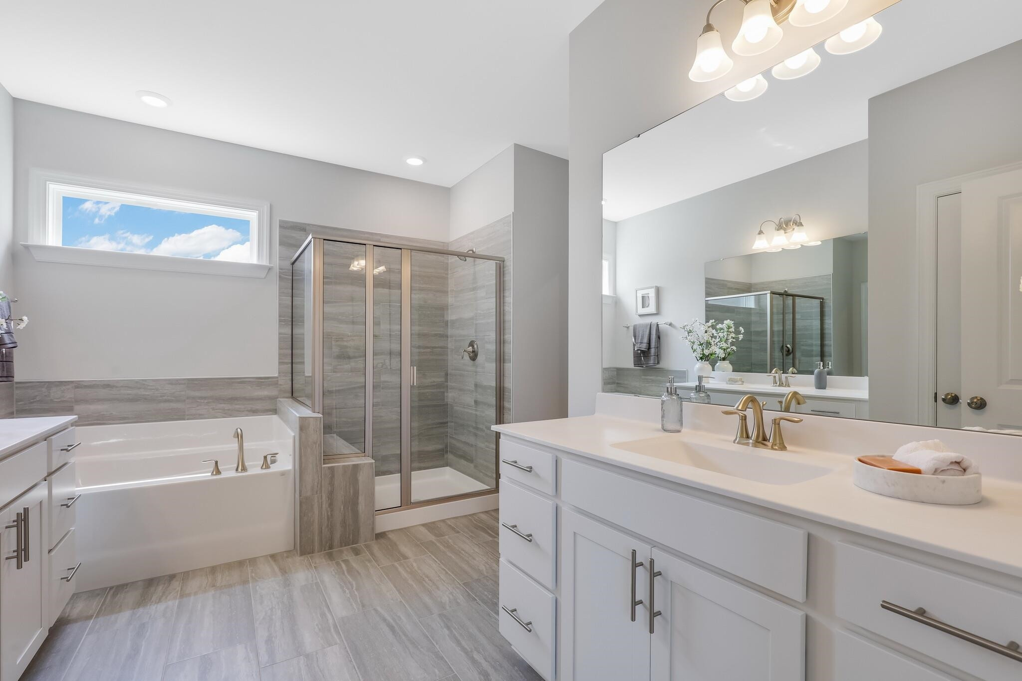 116 Canyon Gap Way, Unit 177 Raleigh, NC 27610 - Photo 27 of 38 a bathroom with a tub a sink double vanity and mirror