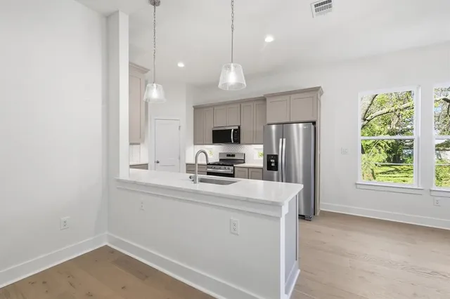 a kitchen with stainless steel appliances a refrigerator sink and microwave
