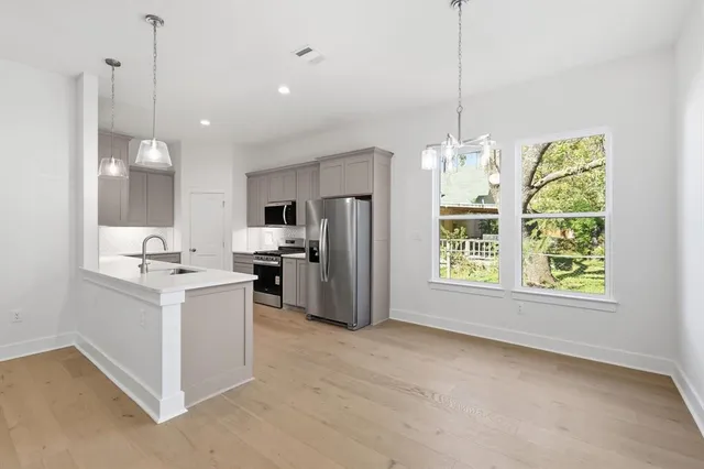 a kitchen with kitchen island a sink appliances and cabinets