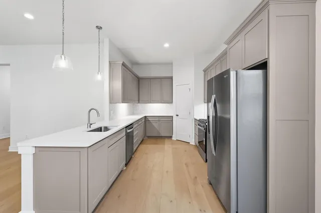a kitchen with granite countertop a sink stainless steel appliances and cabinets
