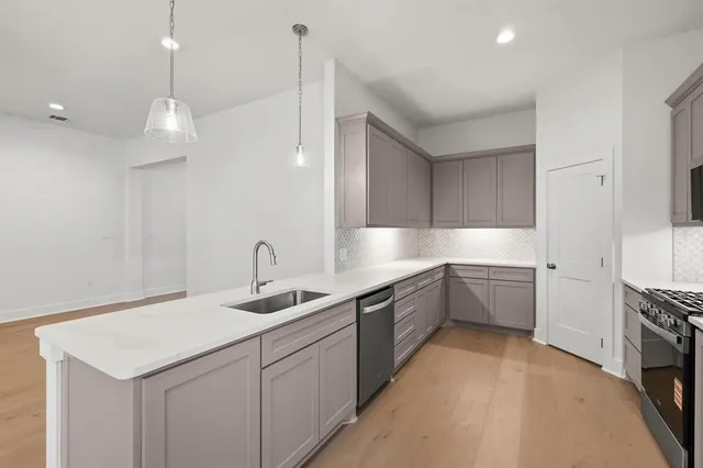 a kitchen with granite countertop a stove a sink and a microwave