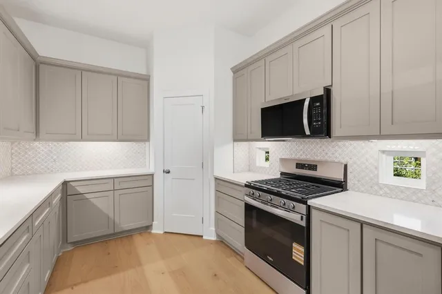 a kitchen with stainless steel appliances granite countertop a stove a sink and a refrigerator