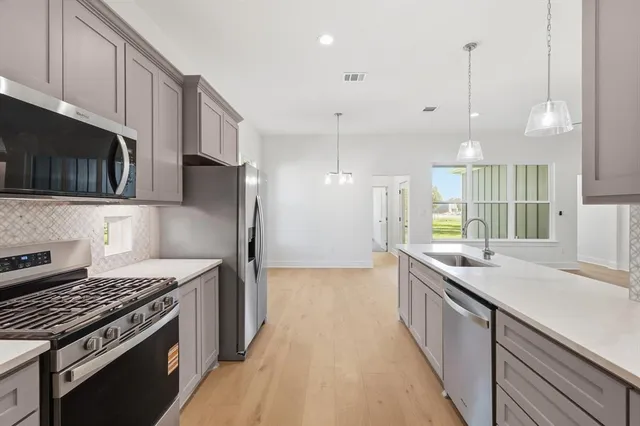 a kitchen with stainless steel appliances white cabinets and a stove top oven