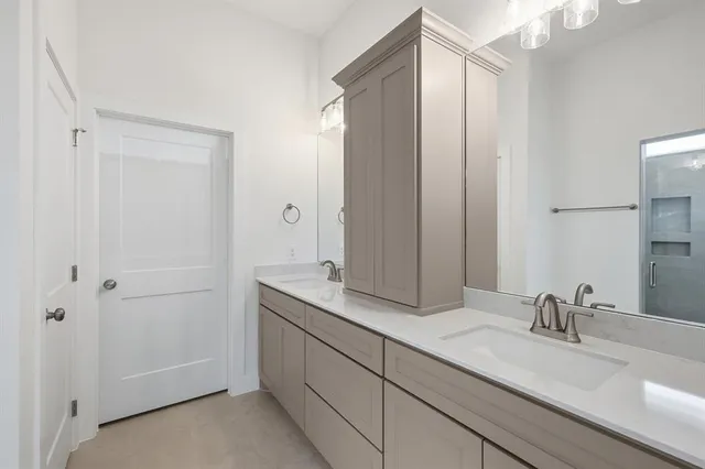 a bathroom with double vanity sinks and a mirror