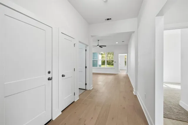 a view of a hallway with wooden floor and closet