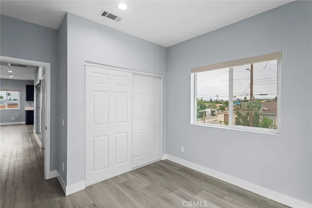 a view of empty room with window and wooden floor