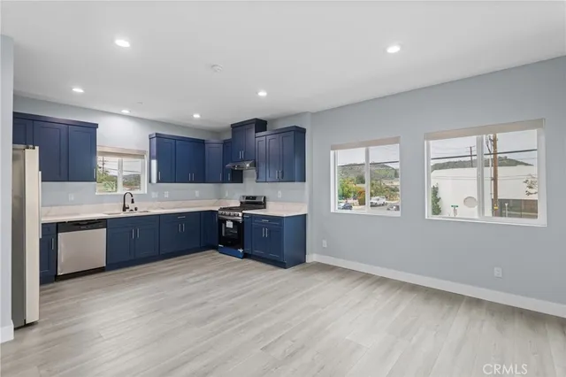 a kitchen with stainless steel appliances granite countertop a refrigerator and a sink