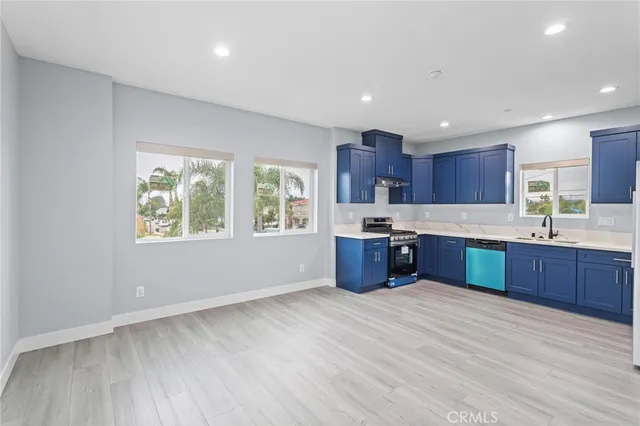 a large kitchen with stainless steel appliances granite countertop a large counter top a sink and a refrigerator