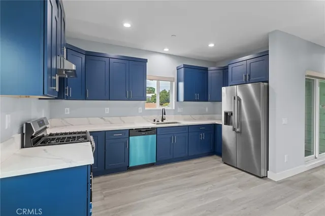 a kitchen with stainless steel appliances granite countertop a stove a refrigerator and a sink