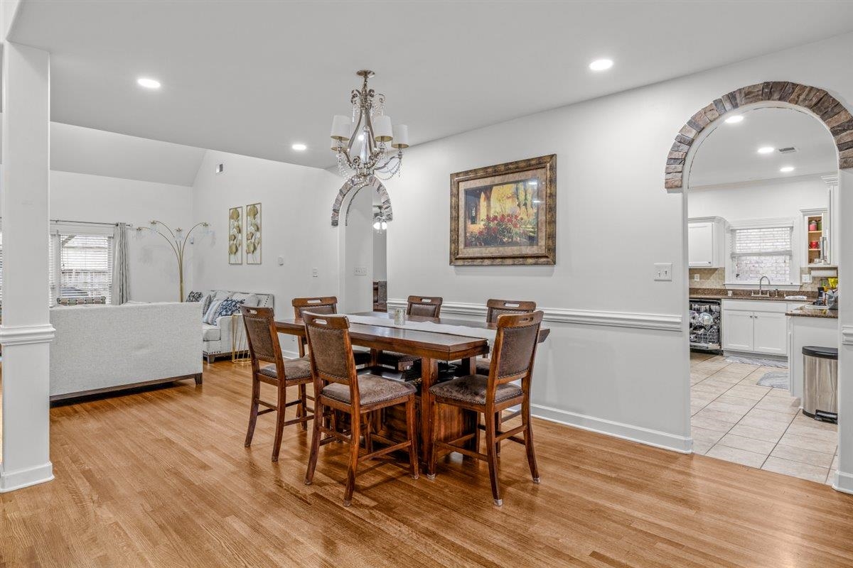 744 Southern Home Road Collierville, TN 38017 - Photo 6 of 24 Open-concept living area with wood-finish flooring, white walls, and decorative stone archways