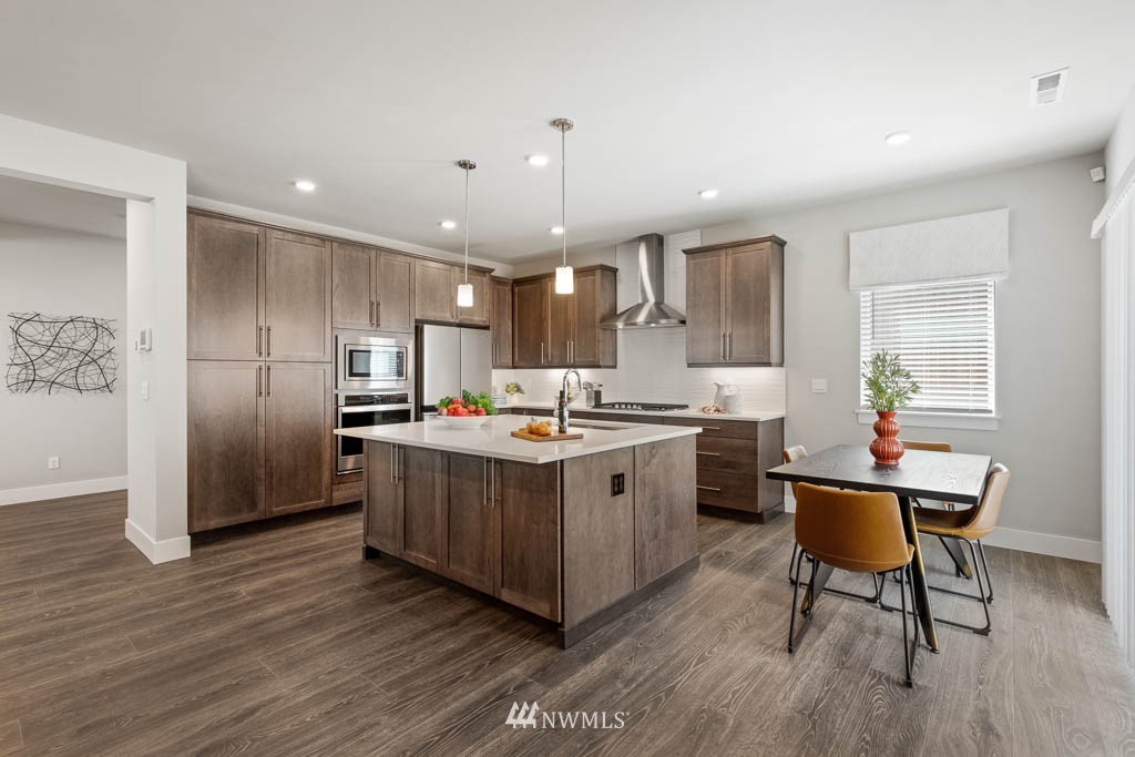 22823 22nd Avenue West, Unit EP 33 Bothell, WA 98021 - Photo 10 of 22 a kitchen with stainless steel appliances granite countertop a refrigerator a sink dishwasher a stove and a microwave oven with wooden floor