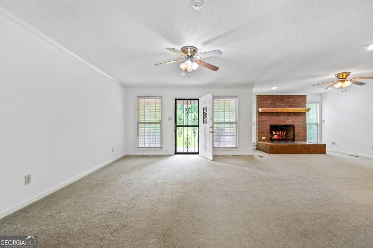 394 Hunter Road Griffin, GA 30224 - Photo 11 of 38 an empty room with windows and fireplace