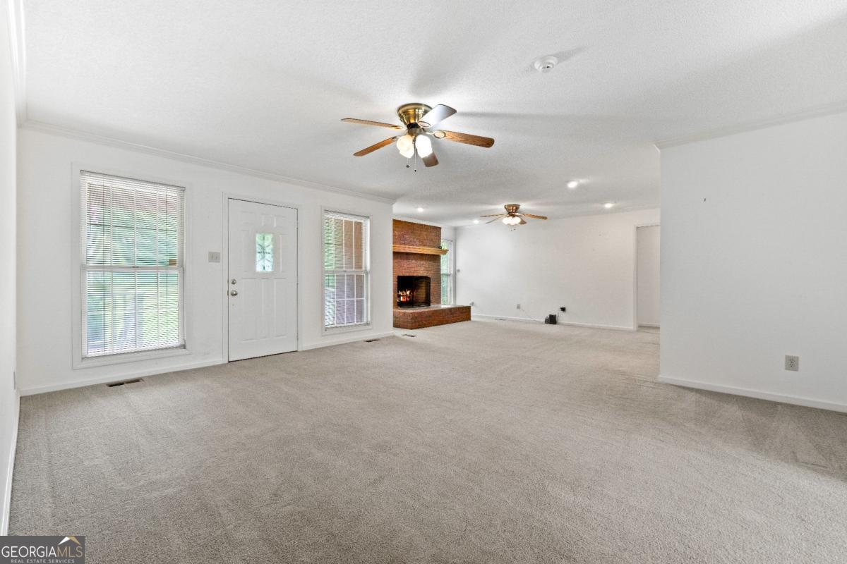 394 Hunter Road Griffin, GA 30224 - Photo 12 of 38 an empty room with chandelier fan and windows