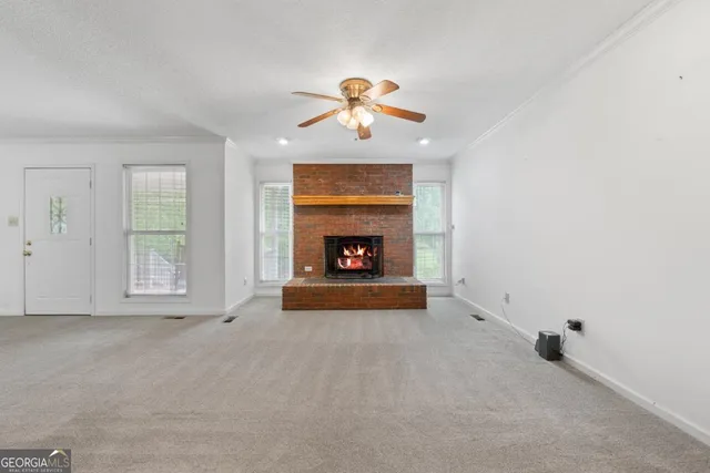 a view of an empty room with window and fireplace