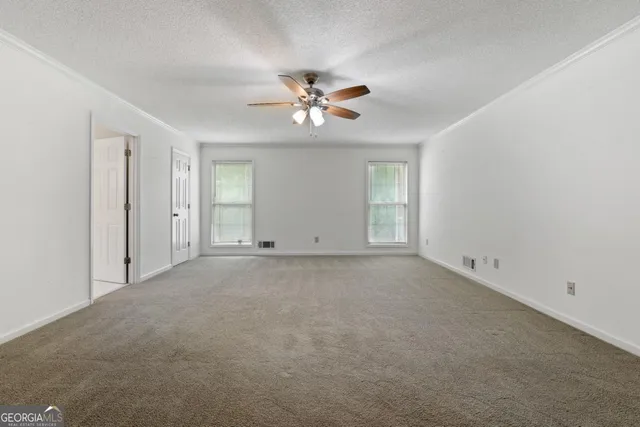 an empty room with closet and a ceiling fan