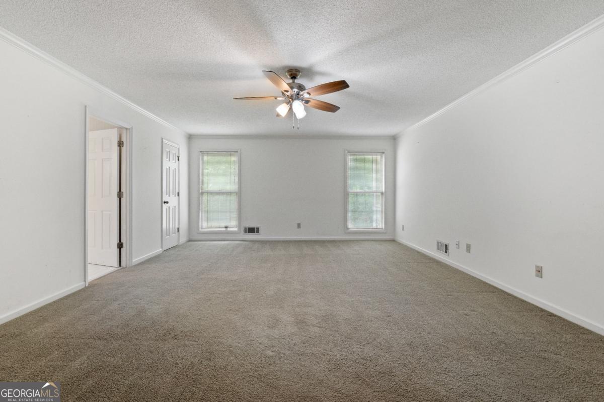 394 Hunter Road Griffin, GA 30224 - Photo 25 of 38 an empty room with chandelier fan and windows