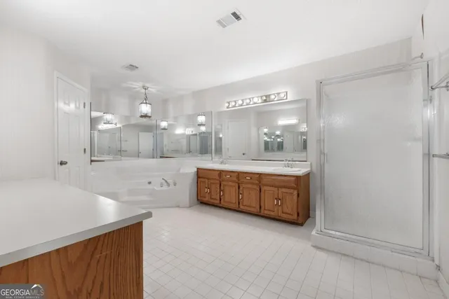 a spacious bathroom with a granite countertop sink mirror and bathtub