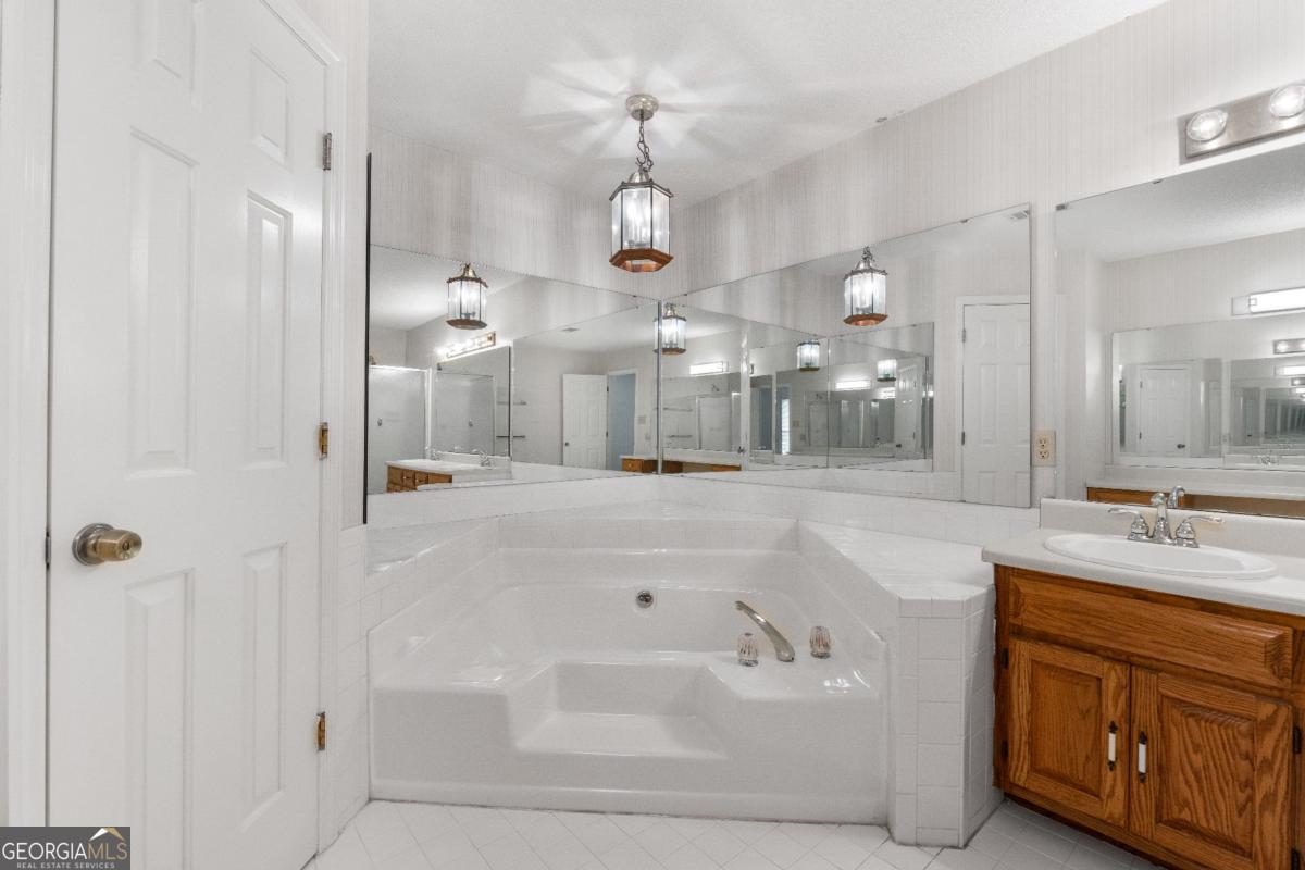 394 Hunter Road Griffin, GA 30224 - Photo 29 of 38 a bathroom with a sink a large mirror and shower