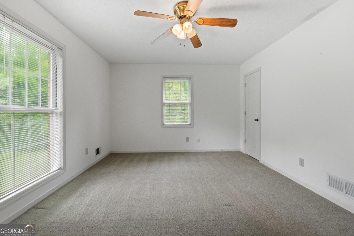 394 Hunter Road Griffin, GA 30224 - Photo 32 of 38 en empty room with windows and chandelier fan