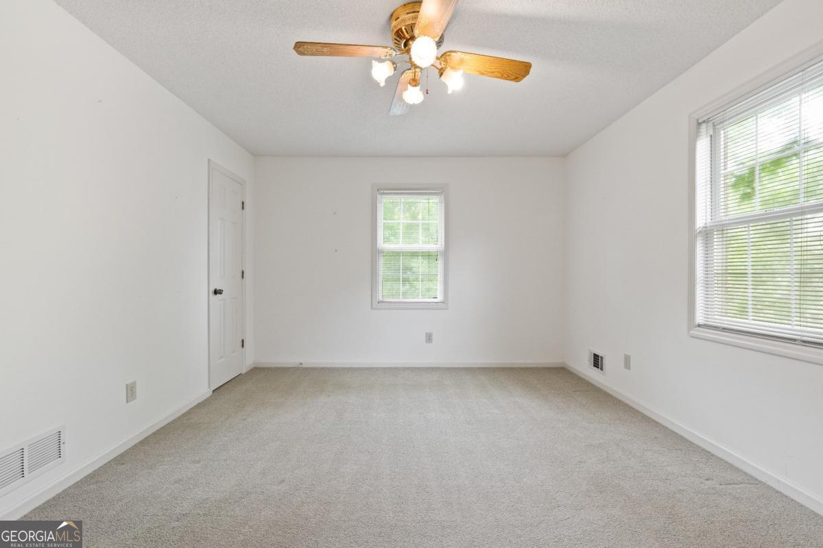 394 Hunter Road Griffin, GA 30224 - Photo 35 of 38 an empty room with windows and chandelier fan