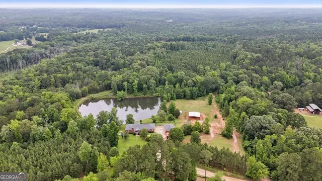 an aerial view of residential house with outdoor space and trees around
