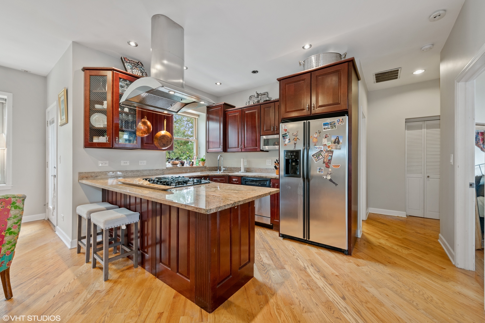 2108 North Spaulding Avenue, Unit 4 Chicago, IL 60647 - Photo 3 of 10 a kitchen with stainless steel appliances granite countertop a refrigerator a sink a stove and a wooden floors