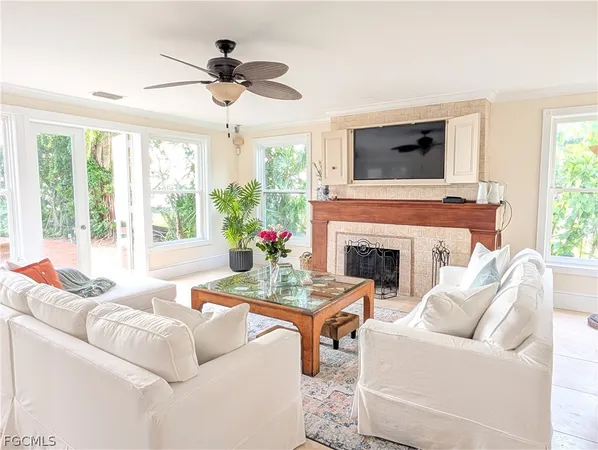a living room with furniture a fireplace and a window