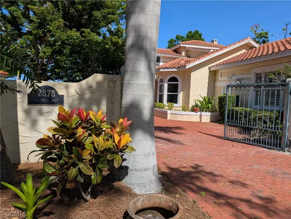 a front view of a house with a yard with potted plants